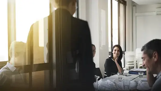 Group of businesspeople in discussion at table in well-lit modern office space
